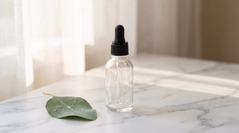 Unbranded dropper scalp serum bottle on marble